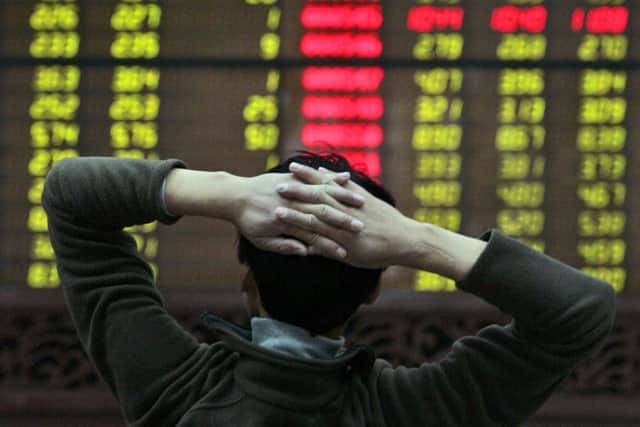 A Chinese investor holds his head back as he looks at the share numbers on the board of a stock trading office in Beijing , China, Thursday, Oct. 16, 2008. Chinese stocks fell further Thursday, dragged down by Wall Street's losses. (AP Photo/ Elizabeth Dalziel)