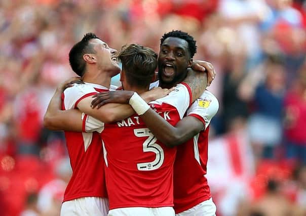 Rotherham United's Richard Wood (left) celebrates with team-mates Rotherham United's Semi Ajayi (right) and Rotherham United's Joe Mattock celebrate promotion vioa the play-offs at Wembley Stadium. Picture: Nigel French/PA