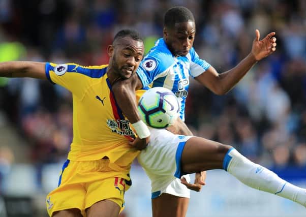 Crystal Palace's Jordan Ayew (left) and Huddersfield Town's Terence Kongolo battle for the ball.
