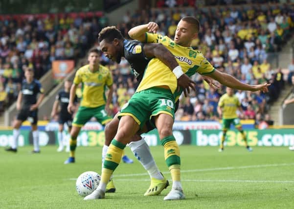 In a tangle: Norwich City's Moritz Leitner and Middlesbrough's Britt Assombalonga tussle at Carrow Road.