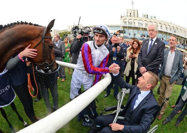 Danny Tudhope congratulates wheelchair-bound PJ McDonald after Laurens won the Matron Stakes at Leopardstown.
