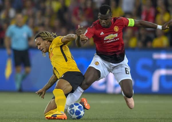 Young Boys' Kevin Mbabu, left, fights for the ball against Manchester United's Paul Pogba. Picture: Anthony Anex/Keystone/AP