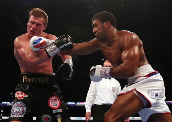 Anthony Joshua (right) lands a right-handed blow on Alexander Povetkin at Wembley Stadium. Picture: Nick Potts/PA