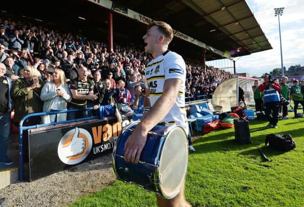 York City Knights's Matt Chilton celebrates the title in front of the stands with a drum.
