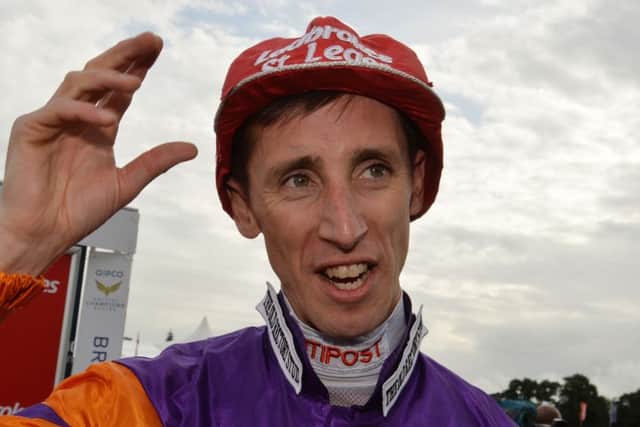 Jockey George Baker dons the famous cap that is traditionally presented to the winning St Leger rider.