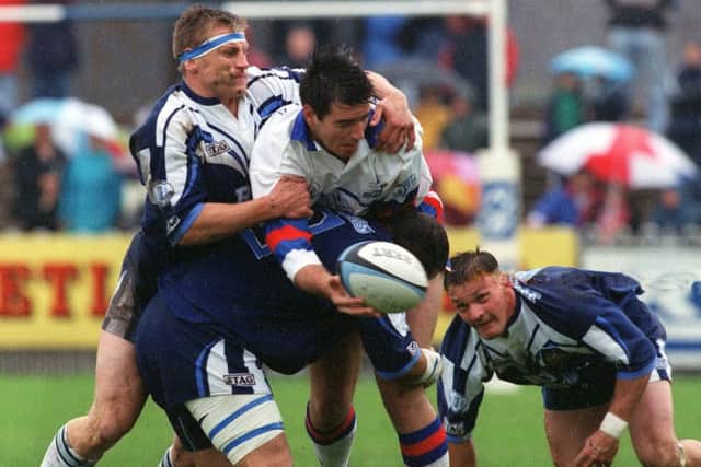 Wakefield Trinity's Adam Hughes is taken down by Featherstone's Carl Hall and Richard Slater.