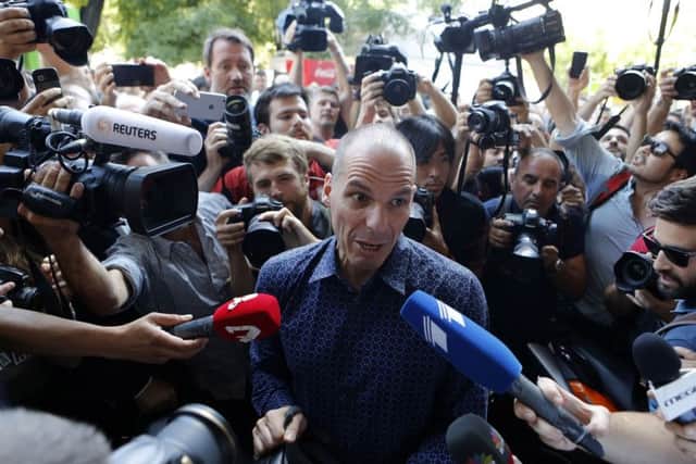 Outgoing Greek Finance Minister Yanis Varoufakis is surrounded by media as he tries to leave on his motorcycle, after his resignation in Athens, Monday, July 6, 2015. (AP Photo/Petros Karadjias)