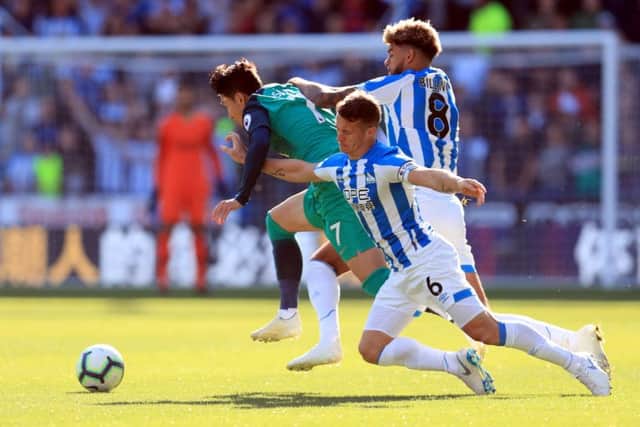 Tottenham Hotspur's Son Heung-min is challenged by Huddersfield Town's Philip Billing (right) and Jonathan Hog.
