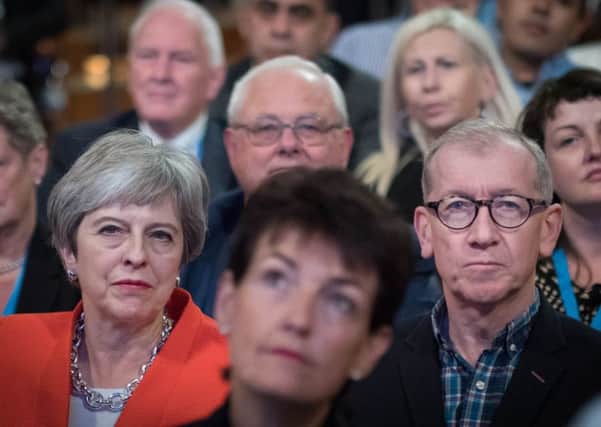 Theresa May and her husband Philip listen intently at the Tory conference.