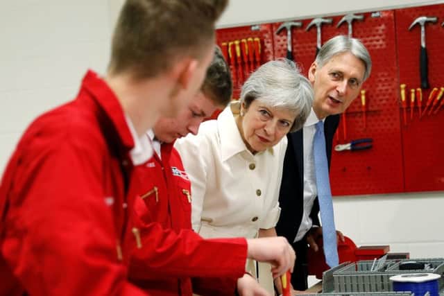 Theresa May and Philip Hammond chat to apprentices in Birmingham during the Tory conference.