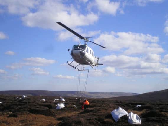Bags of cut heather have been airlifted onto the moor above Deanhead Reservoir to help protect vital peatland.