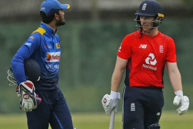 England's Eoin Morgan, right, speaks with Sri Lanka Board XI's captain Dinesh Chandimal after play was interrupted due to bad light. (AP Photo/Eranga Jayawardena)