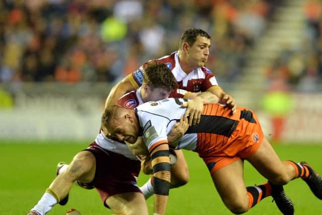 Castleford Tigers' Liam Watts is brought to ground by Wigan. (PIC:BRUCE ROLLINSON)