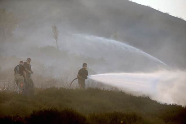Firefighters on Saddleworth Moor in June as they tried to dampen down the area and stop the fire from spreading. Picture by Peter Byrne/PA Wire.