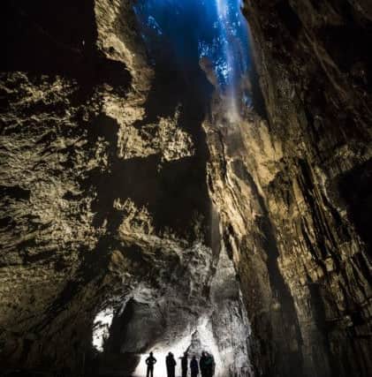 Potholers explore Gaping Gill, the largest cavern in Britain, situated in Yorkshire Dales National Park as it opens to the public this weekend.  PRESS ASSOCIATION Photo. Picture date: Saturday May 26, 2018. The cavern is only open to the public two weekends a year, allowing people to be winched from a hole in the roof and up again for a fee of Â£15. The drop from the moor top to the bottom of Gaping Gill Main Chamber is 110 meters, the same height as St Paul's Cathedral. The Fell Beck stream which created the cavern flows into its roof before plunging to the limestone floor creating Britain's highest unbroken waterfall. Photo credit should read: Danny Lawson/PA Wire
