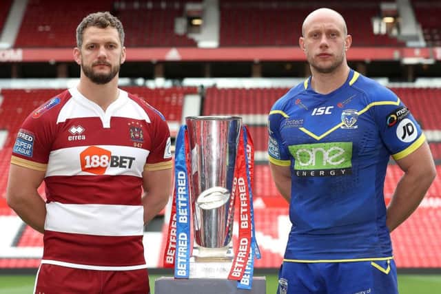 Wigan Warriors Sean O'Loughlin (left) and Warrington Wolves' Chris Hill (right) with a Super League trophy during a photocall at Old Trafford. Picture: Martin Rickett