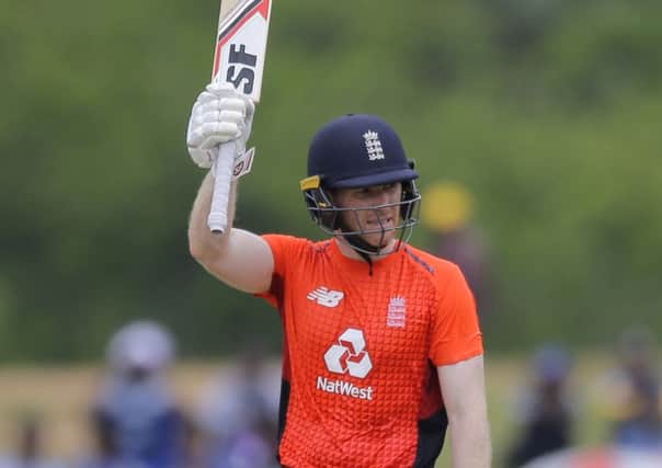 England's Eoin Morgan raises his bat after scoring half a century during their second one-day international cricket match with Sri Lanka in Dambulla, Sri Lanka. (AP Photo/Eranga Jayawardena)