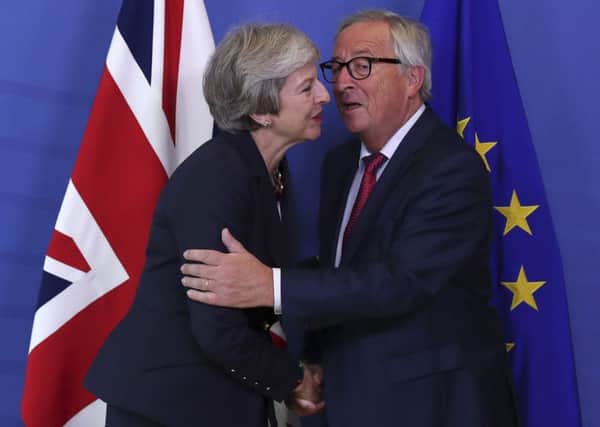 CLOSE, BUT NO DEALl: Prime Minister Theresa May, left, hugs Jean-Claude Juncker, President of the European Commission, as they meet in Brussels. PIC: PA