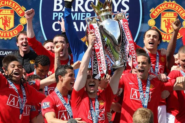 Manchester United's Gary Neville, centre, lifts the Premier League trophy in 2009.