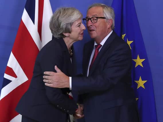 British Prime Minister Theresa May, left, hugs Jean-Claude Juncker, President of the European Commission, as they meet in Brussels. (AP Photo/Francisco Seco)
