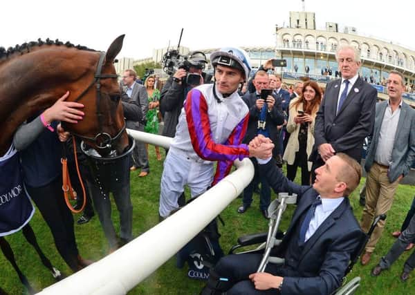 PJ McDonald, pictured in a wheelchair, shakes the hand of Danny Tudhope and tries to celebrate the big race win of Laurens in Leopardstown's Matron Stakes last month.