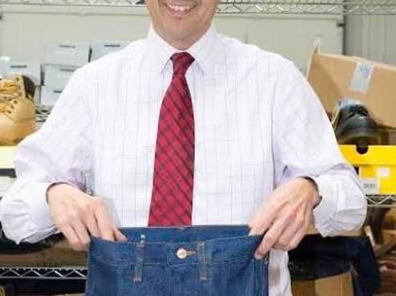 Auctioneer Paul Cooper holding up the tiny jeans