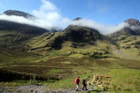 PLANET'S FINEST: Hillwalkers set out towards the Three Sisters mountain range in Glencoe, Scotland. PIC: PA