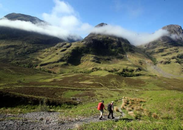 PLANET'S FINEST: Hillwalkers set out towards the Three Sisters mountain range in Glencoe, Scotland. PIC: PA