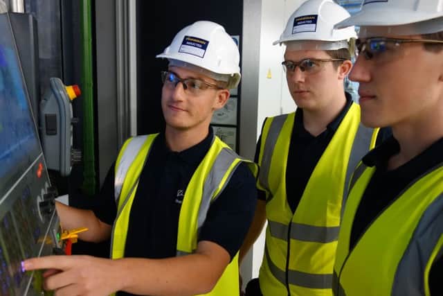 Apprentice machinists at Boeing Sheffield, Rhys Lister, Thomas Pledger and Joshua Thomson. with a five axis horizontal CNC milling machine.