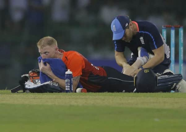 Cramping up: England's Ben Stokes receives treatment.