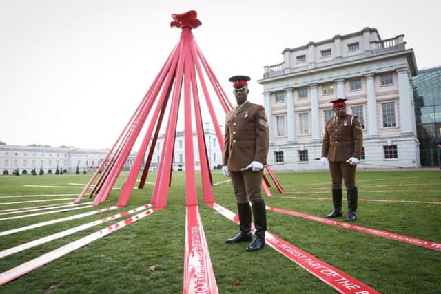 Lance Corporal Lex Raravisa, Blues and Royals (left) and Lance Corporal of Horse Jermaine Brown, Life Guards, standing next to a six metre high poppy, which has been installed at the National Maritime Museum in Greenwich, London, for the launch of the Royal British Legion Poppy Appeal. The instillation links to 14 poignant locations across the UK that all have a connection to the First World War.