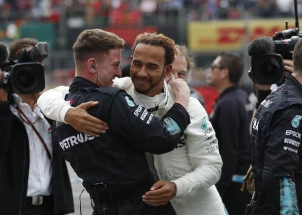 Mercedes driver Lewis Hamilton is congratulated by a member of his crew after claiming his fifth Formula 1 title the Mexico Grand Prix (Picture: Moises Castillo/AP).