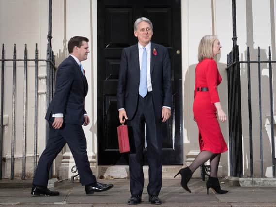 Chancellor Philip Hammond leaves Number 11 Downing Street alongside Treasury Chief Secretary Liz Truss and junior Minister Robert Jenrick ahead of the Budget.