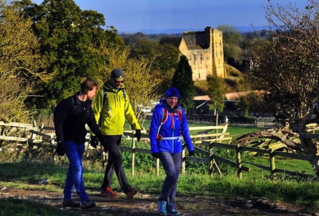 Walkers on the Cleveland way with a backdrop of Helmsley Castle.