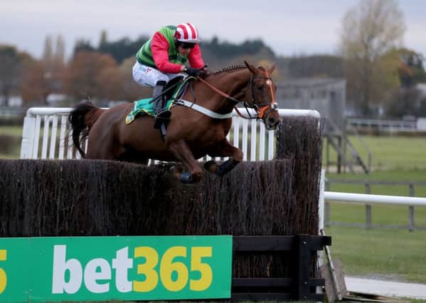 Definitly Red and Danny Cook clear the last in the bet 365 Charlie Hall Chase.