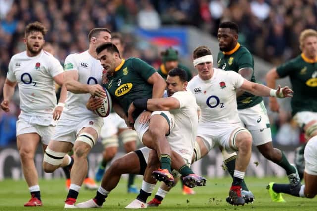 South Africa's Damian de Allende attempts a break away and is tackled by England's Ben Te'o at Twickenham. Picture: Adam Davy/PA