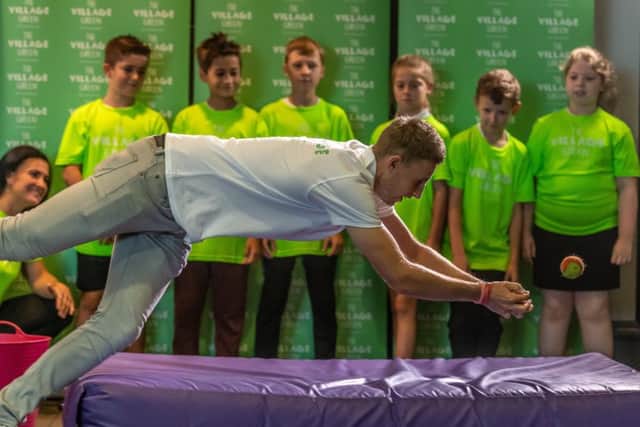 MAN FOR ALL SEASONS: Joe Root demonstrates catching practice to children from Morley Newlands Primary School at a special event held last month by Village Hotels Club.
 Picture: James Hardisty.