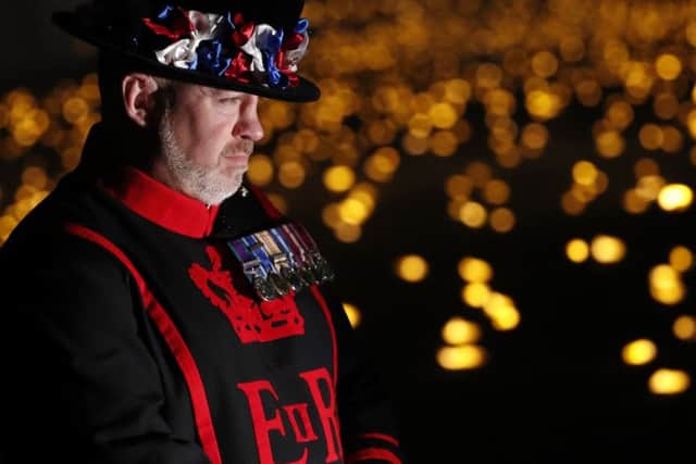 A Yeoman Warder, commonly referred to as a 'Beefeater', stands amongst thousands of lit flames which form part of an installation called 'Beyond the Deepening Shadow: The Tower Remembers', in the dry moat of the Tower of London, to mark the centenary of the end of World War One.