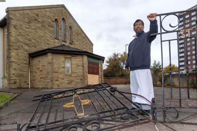 Father Benny Thomas assesses the damage to St Wilfrids Church.