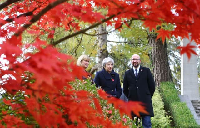 Theresa May at the St Symphorien Military Cemetery in Mons, Belgium, with Belgian Prime Minister Charles Michel and Liz Sweet, of the Commonwealth War Graves Commission.