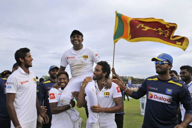 Sri Lankan cricket team members carry their bowler Rangana Herath who played his career last test cricket match. (AP Photo/Eranga Jayawardena)