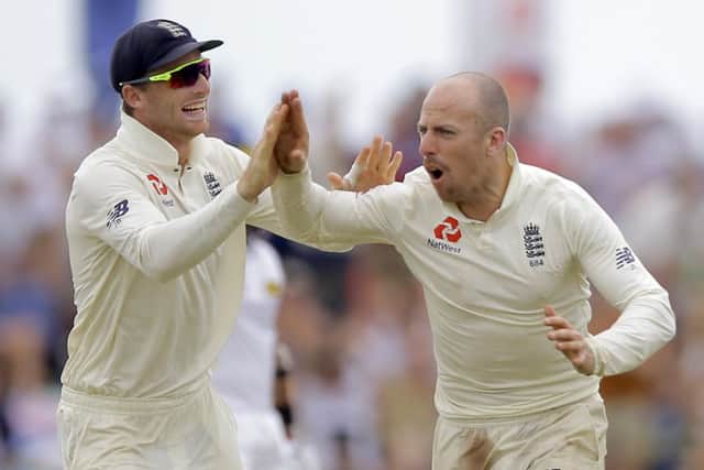 England's Jack Leach celebrates the dismissal of Sri Lanka's Kusal Mendis with teammate Joss Buttler, left, during the fourth day. (AP Photo/Eranga Jayawardena)