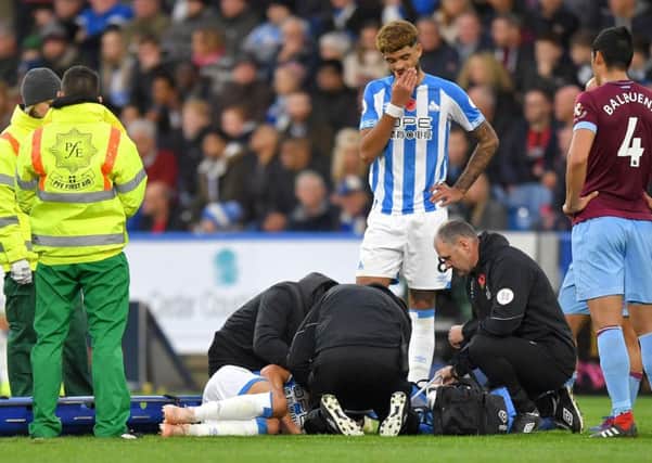 Huddersfield Town's Chris Lowe receives medical attention.