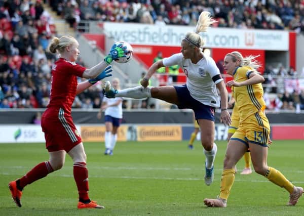 Sweden goalkeeper Hedvig Lindahl makes a save ahead of England's Rachel Daly.