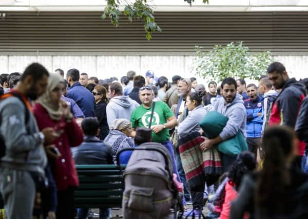 Migrants gather in front of the reception centre for refugees and asylum seekers as they wait for registration in Berlin in 2015