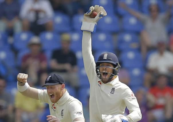 England's wicketkeeper Ben Foakes celebrates taking a catch to dismiss Sri Lanka's Angelo Mathews with Ben Stokes on day two in Pallekelle. Picture: AP/Eranga Jayawardena