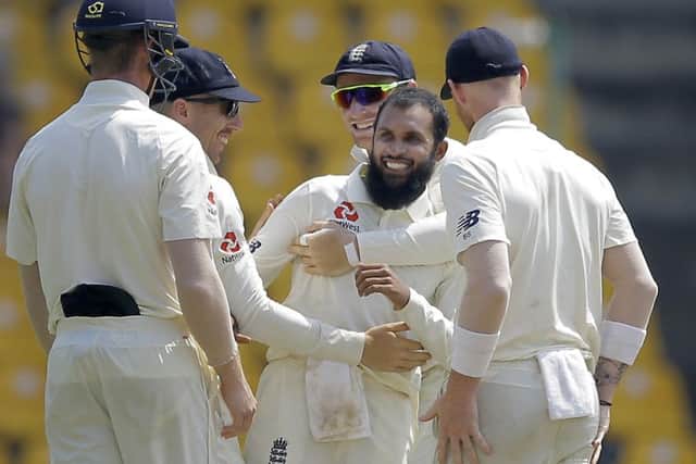 England's Adil Rashid, second right, is congratulated by his team mates for taking the wicket of Sri Lanka's Dhananjaya de Silva on day two in Pallekele. Picture: AP/Eranga Jayawardena