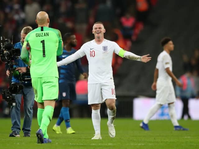 USA goalkeeper Brad Guzan (left) and England's Wayne Rooney share a laugh after the final whistle.