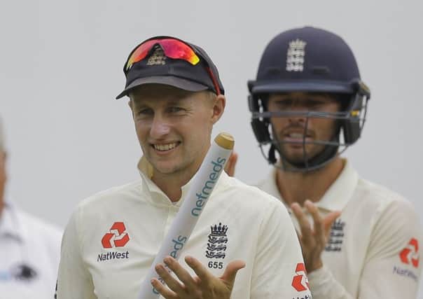 England's captain Joe Root, left, and Ben Faokes celebrate their victory over Sri Lanka by 57 runs in the second test cricket match between Sri Lanka and England in Pallekele, Sri Lanka, Sunday, Nov. 18, 2018. (AP Photo/Eranga Jayawardena)