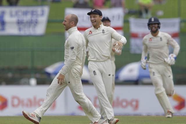 England's Jack Leach, left, celebrates taking a catch to dismiss Sri Lanka's Malinda Pushpakumara with his teammates in Pallekele. Picture: AP/Eranga Jayawardena.